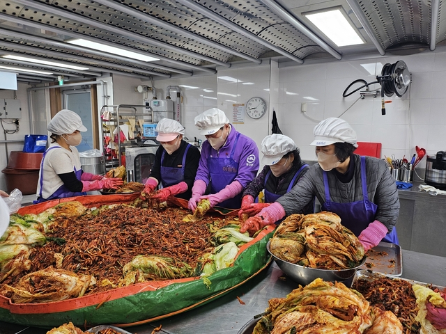 이필형(가운데) 동대문구청장이 김장 나눔 행사에서 배추를 버무리고 있다. 동대문구청 제공
