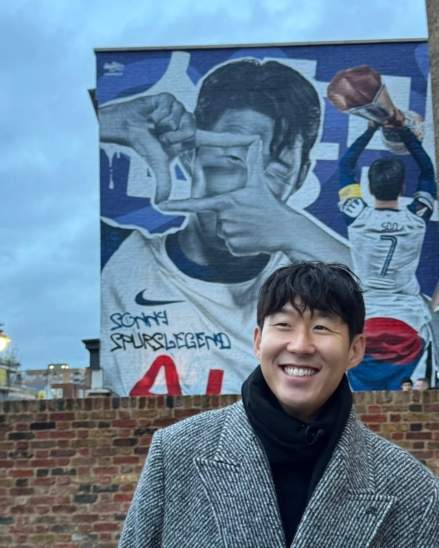 손흥민이 영국 런던의 토트넘 홋스퍼 스타디움 인근 토트넘 하이로드의 한 건물에 그려진 자신의 벽화 앞에서 활짝 웃고 있다.토트넘 홋스퍼 SNS