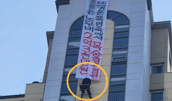 10일 오후 전남 나주시 빛가람동의 아파트에서 도장 업체 관계자가 현수막을 내걸고 고공농성을 벌이고 있다. 뉴시스 독자 제공