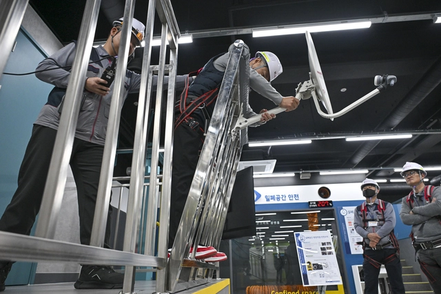 KT 현장 작업자들이 난간대 안테나 제거 모의체험을 하는 모습.  KT 제공