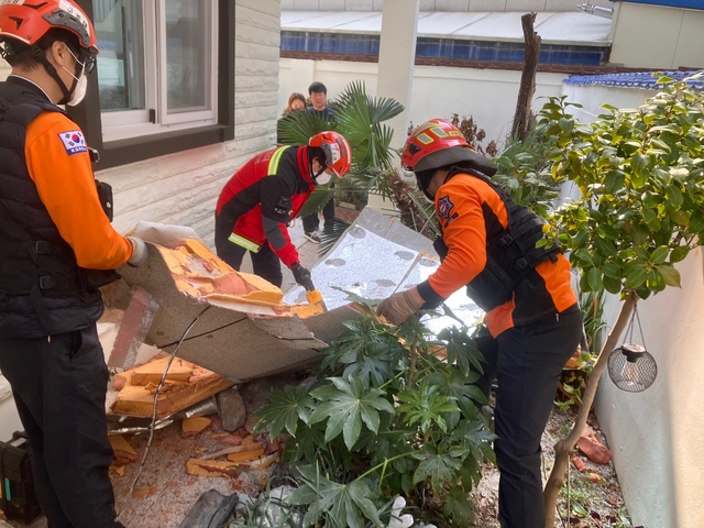 지난 10일 소방대원들이 강풍에 이탈한 빌라 외장재를 정리하고 있다. 부산소방재난본부 제공