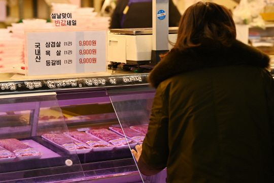 지난 2023년 서울 망원시장 내 한 정육점에서 시민들이 삼겹살 등의 가격을 확인하고 있다. 문호남 기자