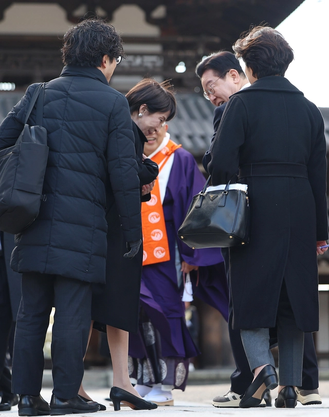 이재명 대통령과 다카이치 사나에 일본 총리가 14일 일본 나라현 대표 문화유적지인 호류지(법륭사)에서 기념촬영을 마친 뒤 이 대통령이 착용한 운동화에 대해 이야기를 하고 있다. 연합뉴스