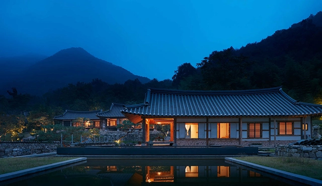 해질 녘 물빛에 반사된 아원고택 안채의 야간 경관 모습.  아원고택 제공