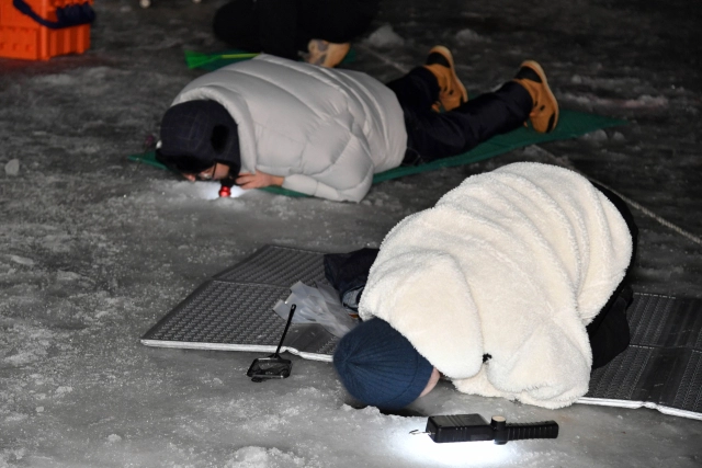 화천산천어축제가 개막한 지 2주째를 맞은 가운데 지난 17일 축제장인 강원 화천군 화천천에서 관광객이 밤낚시를 즐기고 있다. 화천군 제공