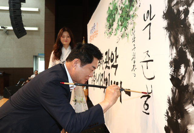 박준희 관악구청장이 지난해 8월 직원 청렴교육 때 진행된 캘리그래피 퍼포먼스에서 이름을 적어넣고 있다. 관악구청 제공