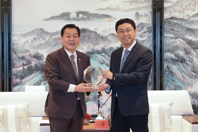 이재준(왼쪽) 경기 수원시장이 19일 중국 주하이(珠海)시 호텔에서 우저통(吳澤洞) 시장으로부터 우호결연 20주년 감사패를 받고 있다. 수원시청 제공