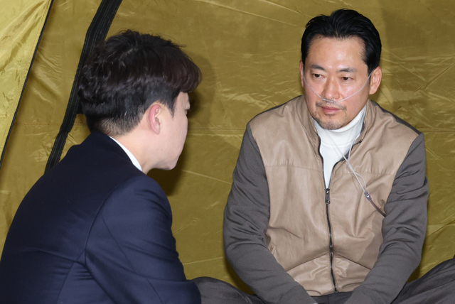 장동혁 국민의힘 대표가 21일 서울 여의도 국회 로텐더홀 단식 농성장을 찾은 개혁신당 이준석 대표와 대화하고 있다. 연합뉴스