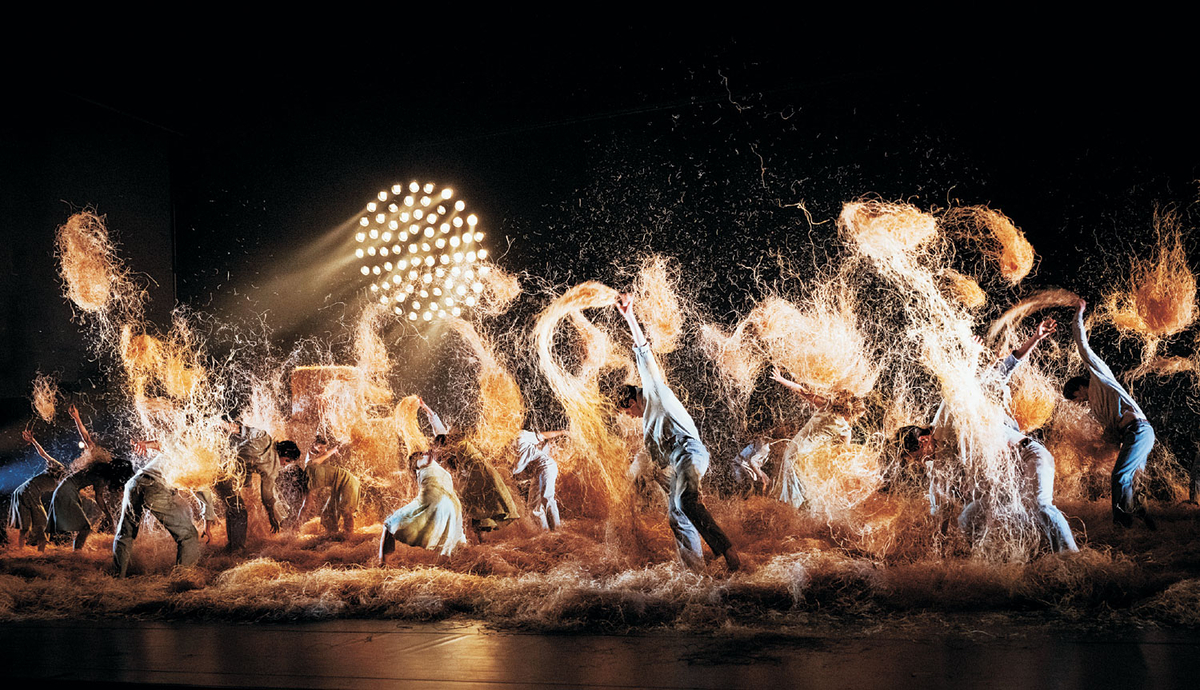 알렉산더 에크만의 ‘한여름 밤의 꿈’. 해질녘 노을처럼 보이는 조명 아래 무용수들이 바닥의 건초 더미를 헤집으며 군무를 선보이고 있다.  LG아트센터 제공