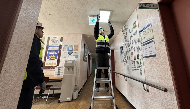 한전KDN 관계자가 에너지 복지서비스 ‘따밝동행‘ 2차 사업 실천으로 전남 나주시 다도면에 위치한 사회복지시설 ‘부활의 집’의 노후 조명 시설을 교체하고 있다. 한전KDN 제공