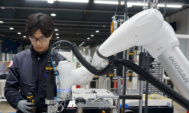 경기 수원시 권선구에 위치한 두산로보틱스 공장 내 생산·테스트 라인에서 작업자와 협동로봇이 함께 제품을 조립하고 있다.  두산그룹 제공