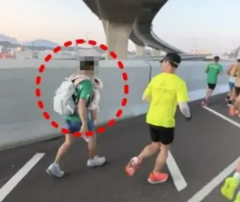 홍콩에서 열린 국제 마라톤 대회에서 한 남성 참가자가 아기를 가슴에 안고 달리다 퇴장 당했다. 쓰레드 캡처