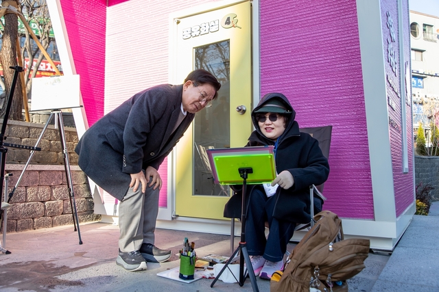 박강수(왼쪽) 마포구청장이 ‘그림동네 공유화실’에서 작가의 그림을 감상하고 있다. 마포구청 제공