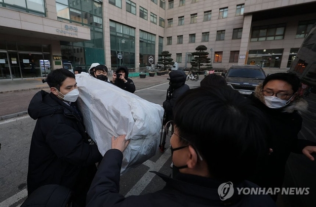 북한의 한국 무인기 침투 주장에 대한 진상을 규명하는 ‘군경합동조사 TF’가 지난 21일 민간인 피의자 3명의 주거지 및 사무실 등에 대한 압수수색에 나선 가운데 이날 피의자 장모씨와 오모씨가 다니던 서울의 한 대학교 공대 건물에서 경찰 관계자들이 압수품을 옮기고 있다. 연합뉴스