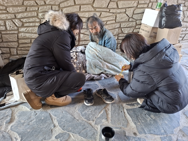 동대문구 관계자가 한파 속 거리 노숙인에게 방한 물품을 전달하며 보호 활동을 하고 있다. 동대문구청 제공
