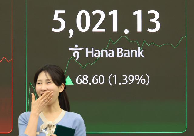 21일 서울 중구 하나은행 본점에서 한 직원이 코스피 지수 앞을 지나고 있다. 이날 코스피는 상승 출발해 장 초반 5천포인트를 넘어서는 등 등·하락을 반복하다 5021.13으로 사상 최고가 경신했다. 연합뉴스