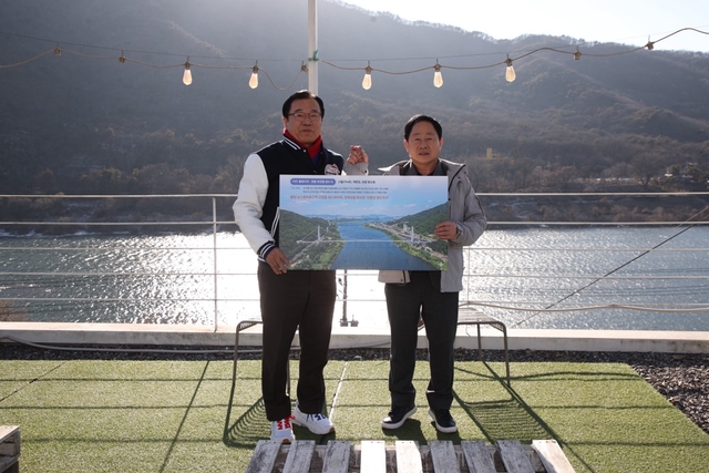 주광덕(오른쪽) 남양주시장과 이현재 하남시장이 한강 수변과 예봉산·검단산 일대를 연결하는 ‘친환경 출렁다리’ 조성 청사진을 들고 기념촬영을 하고 있다. 남양주시 제공