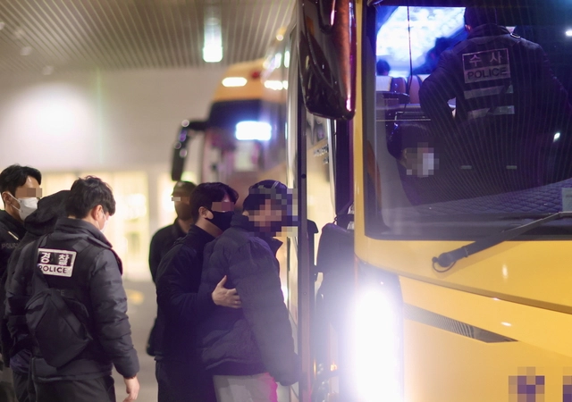 부산경찰청 수사관들이 캄보디아 사기 범죄 가담자들을 압송 버스에 태우고 있다. 부산경찰청 제공