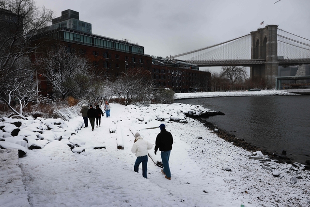 지난달 27일 미국 뉴욕 주민들이 눈 쌓인 강가를 걷고 있는 모습. AFP 연합뉴스