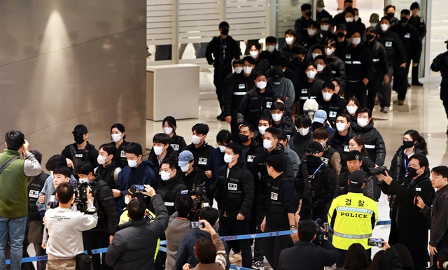 기나긴 송환 행렬. 캄보디아에서 스캠(사기) 및 강력 범죄를 일삼은 혐의로 강제 송환된 한국인 73명이 23일 오전 대한항공 KE9690편 전세기를 타고 인천 중구 인천국제공항에 도착, 경찰에 압송되고 있다. 박윤슬 기자