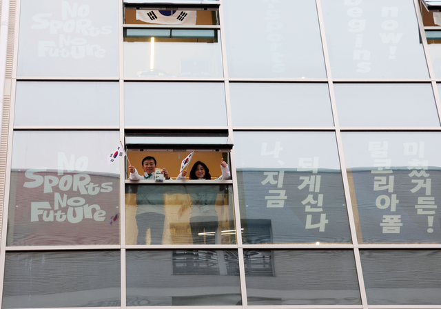 이수경(오른쪽) 대한민국 선수단장과 김택수 부단장이 3일 밤(한국시간) 이탈리아 밀라노의 2026 밀라노·코르티나동계올림픽 선수촌 내 숙소에서 태극기를 흔들고 있다.  뉴시스