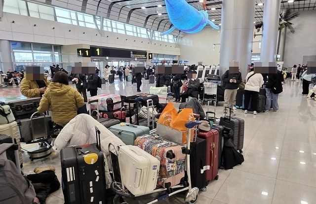 8일 오전 제주국제공항이 폭설로 운영이 중단된 가운데 제주공항 3층 출발장에서 이용객들이 운항 재개를 기다리고 있다. 연합뉴스