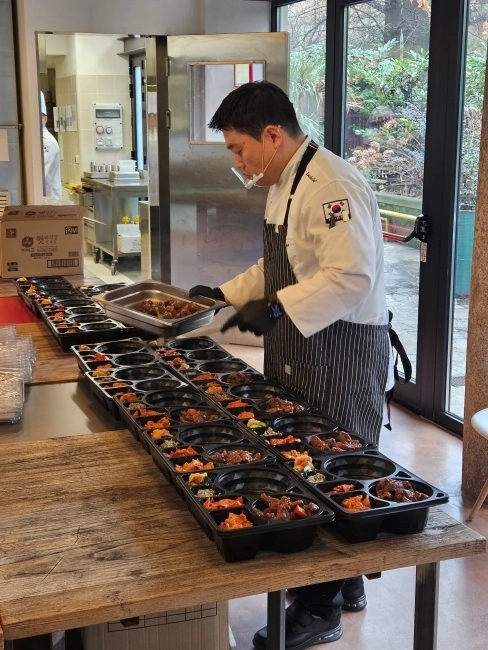 김중현 진천선수촌 조리장이 9일(현지시간) 이탈리아 밀라노의 대한체육회 급식지원센터에서 선수들에게 제공될 도시락의 반찬을 나눠 담고 있다. 밀라노=오해원 기자