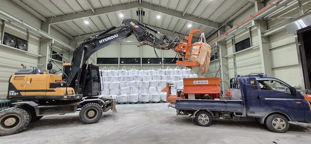 경기도내 한 제설제 창고에서 굴착기가 트럭에 염화칼륨을 충전하고 있다. 경기도청 제공