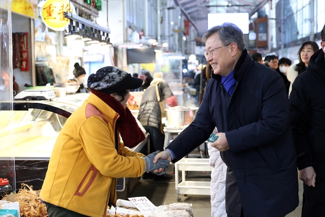 장인홍 서울 구로구청장(오른쪽)이 지난달 30일 설을 앞두고 관내 전통시장을 방문해 시장 상인들과 인사를 나누고 있다. 구로구청 제공