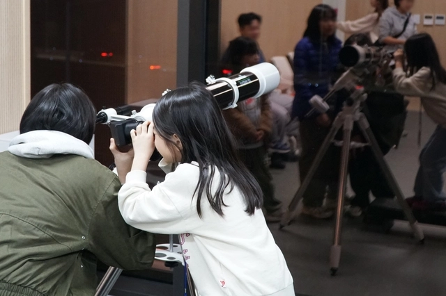 마포365천문대에서 아이와 어머니가 망원경을 통해 별을 바라보고 있다. 마포구청 제공