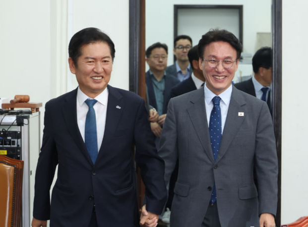 김민석 국무총리가 서울 여의도 국회 더불어민주당을 예방, 정청래 대표와 함께 손을 잡고 회의실로 입장하고 있다. 뉴시스