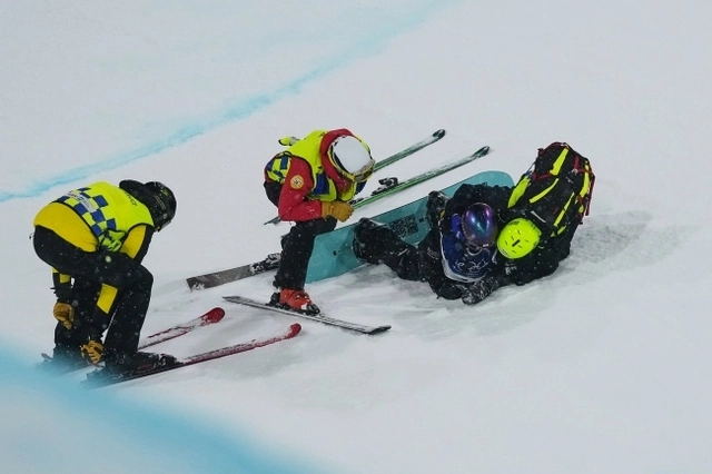 최가온이 13일 오전(한국시간) 이탈리아 리비뇨 스노파크에서 열린 2026 밀라노·코르티나동계올림픽 여자 스노보드 하프파이프 결선 1차 시기 도중 벽과 충돌해 슬로프에 쓰러져 의료진과 대화를 하고 있다. AP뉴시스