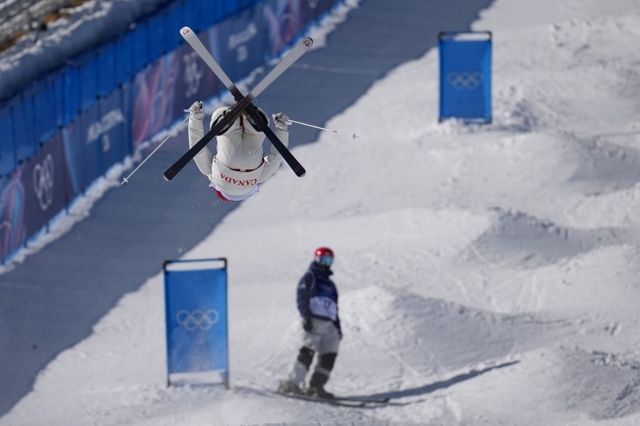 정대윤(아래)이 15일(한국시간) 이탈리아 리비뇨 에어리얼 모굴 파크에서 열린 미카엘 킹즈버리(캐나다)와 2026 밀라노·코르티나동계올림픽 프리스타일스키 남자 듀얼 모굴 8강 경기 도중 코스를 이탈한 뒤 함께 경기한 캐나다의 미카엘 킹즈버리가 시도하는 공중 동작을 바라보고 있다. AP뉴시스