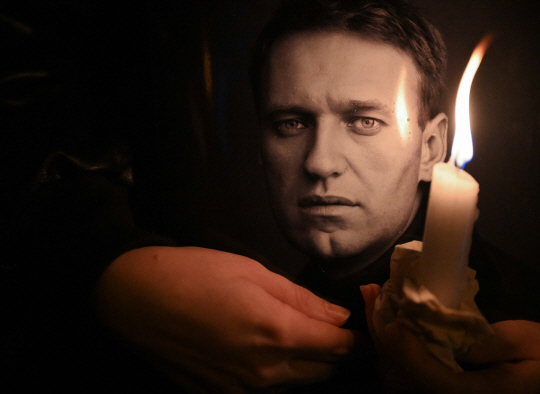 지난 2024년 2월 16일 독일 프랑크푸르트의 옛 러시아 영사관 앞에서 한 남성이 러시아 반정부 운동가 알렉세이 나발니의 사진 앞에 초를 켜고 그의 죽음을 추모하고 있다. AFP연합뉴스