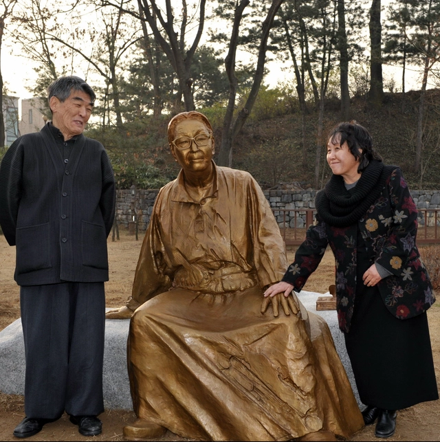 지난 2009년 강원 원주시 박경리 작가 옛집에 세워진 동상을 보며 사위 김지하(왼쪽), 딸 김영주 씨가 웃고 있다.  연합뉴스