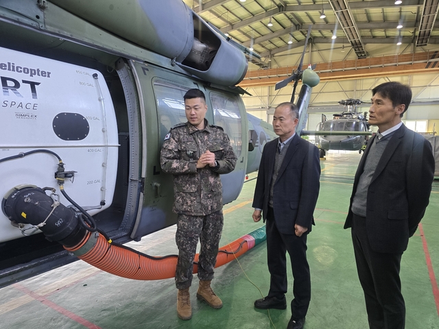 3일 육군항공사령부를 방문한 박정은(가운데) 방위사업청 기반전력사업지원부장이  성능개선된 UH-60 헬기의 화재진화장비에 대해 군 관계자에게 설명을 듣고 있다. 방사청 제공