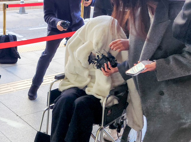 약에 취한 상태로 외제 SUV 차량을 몰고 반포대교를 달리다 한강 둔치로 추락한 운전자 A씨가 27일 서울 마포구 서부지방법원에서 열린 구속 전 피의자 심문(영장실질심사)에 옷으로 얼굴을 가리고 휠체어를 탄 채 출석하고 있다.  연합뉴스