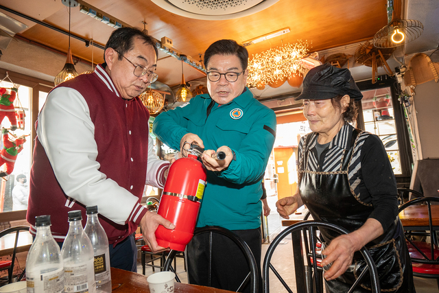 이필형 동대문구청장이 휘경동에 위치한 파전 골목을 찾아 상인에게 소화기 작동법을 설명하고 있다. 동대문구청 제공