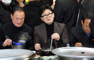 한동훈(왼쪽 두 번째) 전 국민의힘 대표가 7일 부산 북구 구포시장을 방문해 국밥을 먹고 있다. 뉴시스