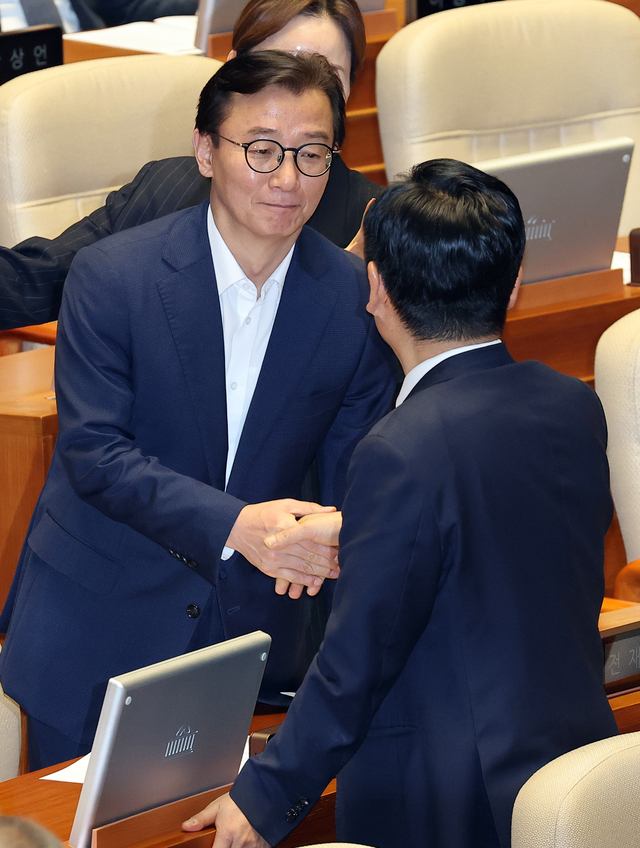 전재수(왼쪽) 더불어민주당 의원과 정청래 민주당 대표가 지난달 25일 국회 본회의에서 만나 악수를 하고 있다. 연합뉴스