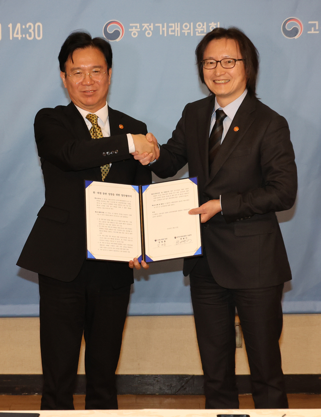 주병기(오른쪽) 공정거래위원회 위원장과 김영훈 고용노동부 장관이 10일 서울 종로구 정부서울청사에서 열린 원·하청 동반 성장을 위한 고용노동부-공정거래위원회 업무협약식에서 협약서에 서명한 뒤 기념촬영을 하고 있다. 연합뉴스