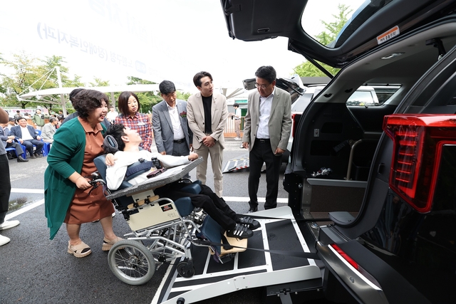 오승록(오른쪽) 서울 노원구청장이 지난해 노원구 장애인 전동보장구운전연습장에서 열린 시승식 행사에서 보조기기를 활용해 차량에 탑승하는 시승 장면을 지켜보고 있다. 노원구청 제공