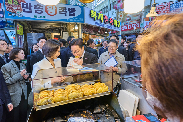이재명 대통령과 김혜경 여사가 15일 경남 창원시 성산구 반송시장을 찾아 붕어빵을 맛보고 있다. 청와대 제공 및 연합뉴스