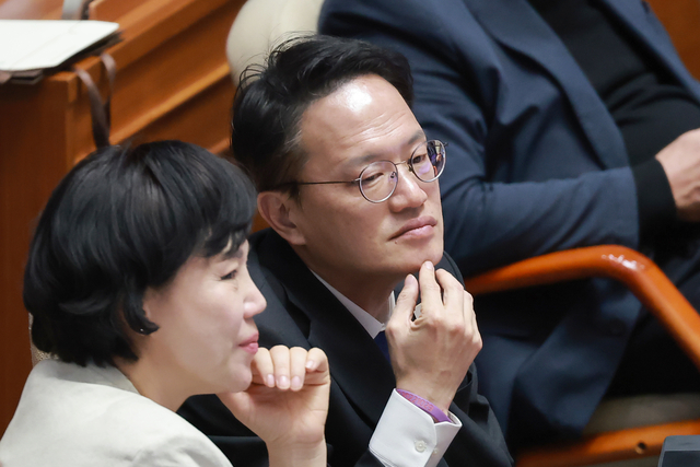 서울시장 경선에 출마한 더불어민주당 박주민(오른쪽) 의원과 전현희 의원이 지난 12일 국회에서 열린 3월 임시국회 본회의에서 대화하고 있다. 연합뉴스
