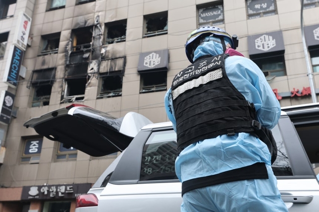 15일 서울 중구 소공동 한 캡슐호텔에서 전날 벌어진 화재사고 조사를 위해 열린 경찰ㆍ소방 등 합동감식에서 한국전기안전공사 사고관리 관계자가 화재현장으로 들어가기 위해 장비를 착용하고 있다. 연합뉴스