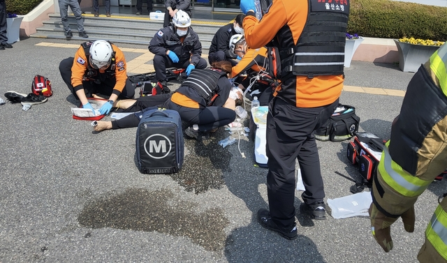 26일 오전 10시 49분쯤 울산 북구 화봉동 동울산세무서앞에서 세금 추징에 항의하며 분신을 시도, 소방대원들이 구조활동을 하고 있다. 울산소방본부 제공