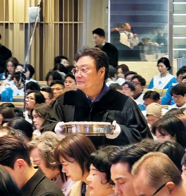 교회 장로인 남진이 올해 봄 성찬식에서 신도들에게 떡을 나눠주는 모습.  새에덴교회 제공