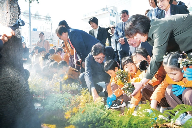 박형준(가운데) 부산시장이 지난 2024년 해피챌린지 준공식에서 주민들과 꽃밭을 조성하고 있다.  부산시청 제공