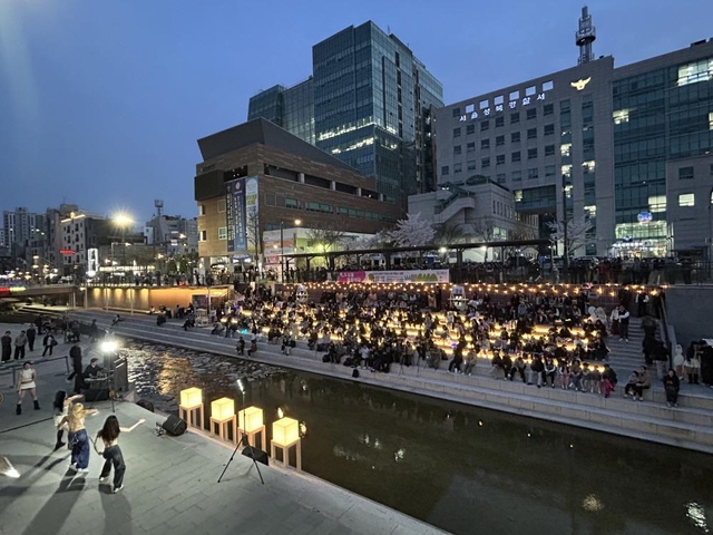 야간 조명이 켜진 성북천 수변활력거점에서 시   민들이 여유롭게 공연과 휴식을 즐기고 있다. 성북구청 제공
