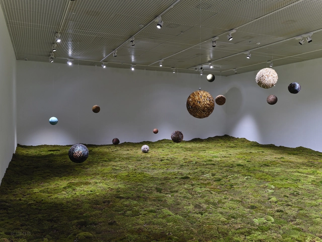 2023년 설치작인 ‘몸을 잃은 새-다다른 곳#3’. 다양한 깃털을 엮어 크고 작은 구를 만들어 달았다. 또, 바닥은 이끼와 흙으로 마무리했다. 삶의 진짜 본질은 무지향적으로 떠도는 것에 있다고 말하는 작품이다.